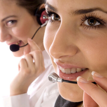 Zwei Frauen mit Headset und Mikrofon.
