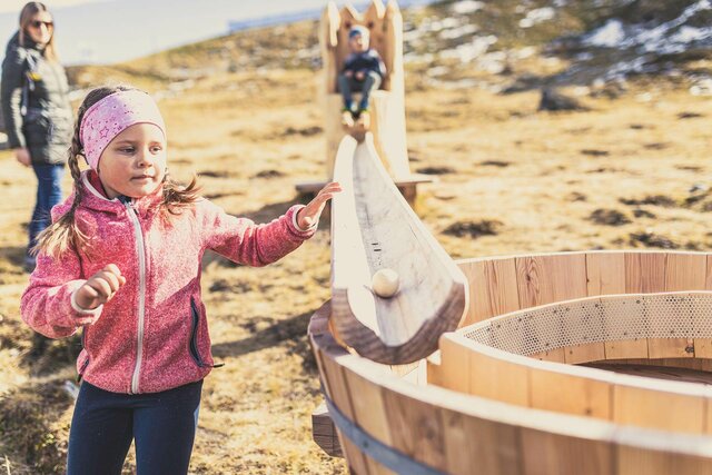 Kinder spielen mit einer Holzkugelbahn