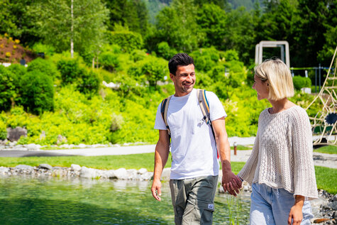 Ein Paar spaziert vor einem Teich