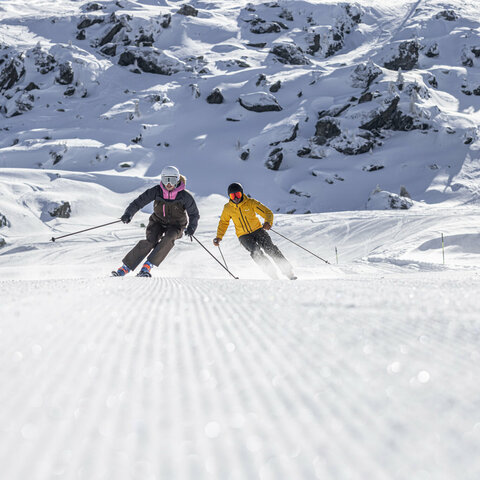 Zwei Skifahrer in verschneiter Pistenlandschaft