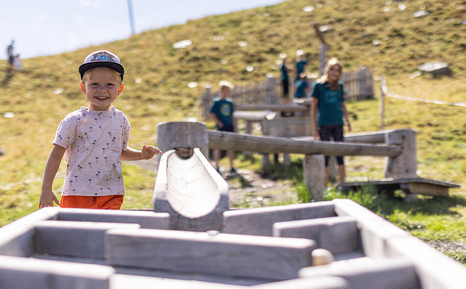 Kinder spielen mit einer Holzkugelbahn