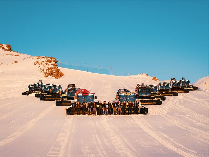 Skiraupen bei Sonnenuntergang mit Menschen davor