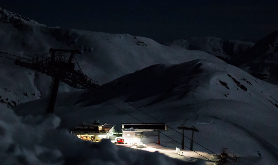 [Translate to EN:] Blick auf eine verschneite Piste bei Nacht.