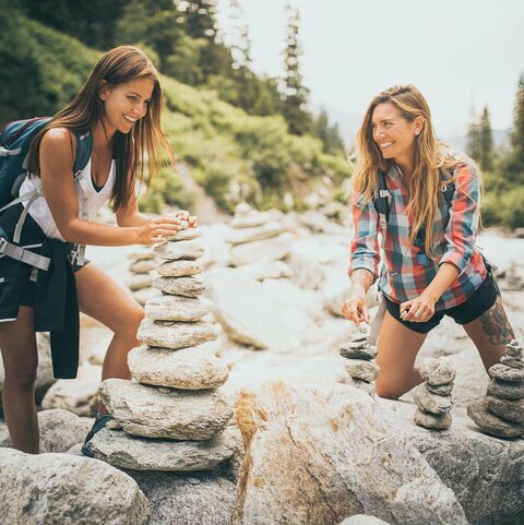 Zwei Frauen bauen Steintürme