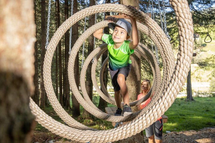 Ein Junge klettert auf einem Parcours