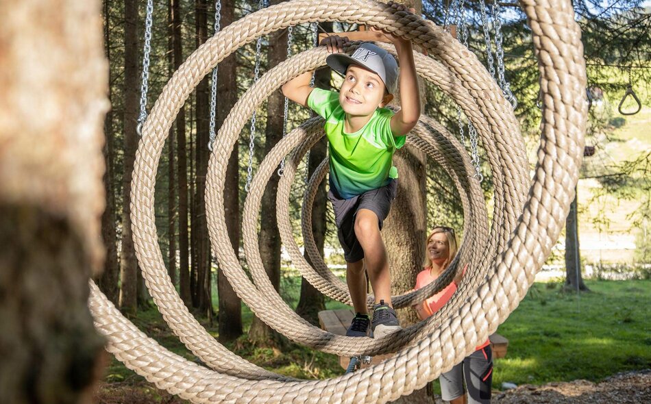 Ein Junge klettert auf einem Parcours