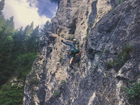 Eine Frau klettert an einer Felswand