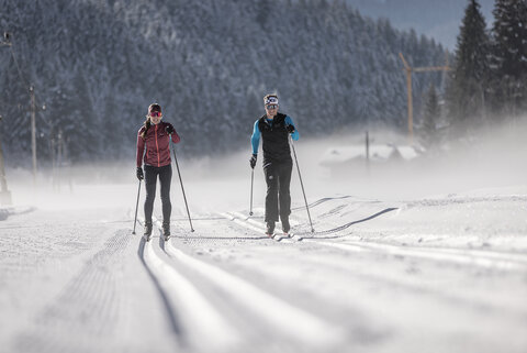 Zwei Langläufer auf einer verschneiten Strecke