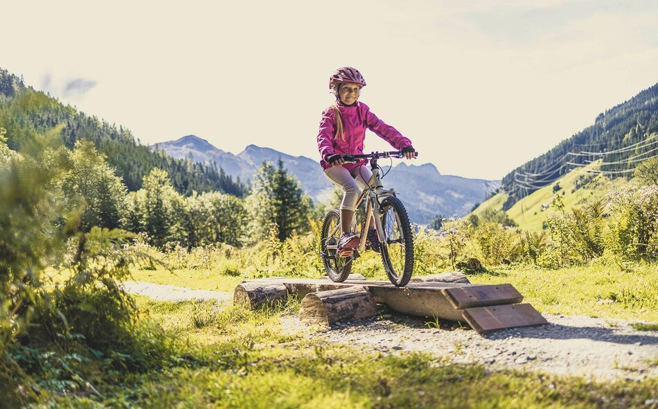 Ein Mädchen fährt auf einem Mountainbike durch den Wald