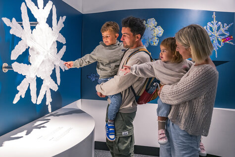 Familie betrachtet eine große Schneeflocke in den Krimmler WasserWelten