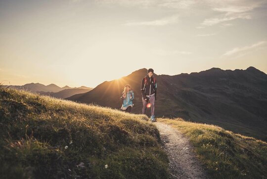 Zwei Frauen wandern vor einem traumhaften Sonnenuntergang
