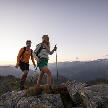 Ein Mann und eine Frau wandern durch eine traumhafte Berglandschaft
