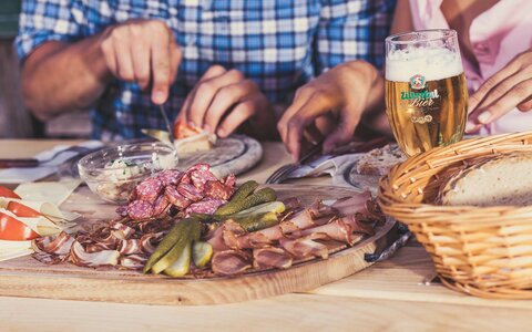 Ein Paar isst eine Wurst- und Käseplatte.