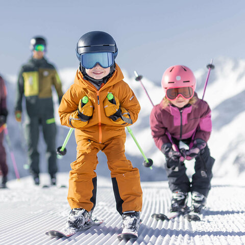 Eine Familie beim Skifahren die Kinder fahren Schuss