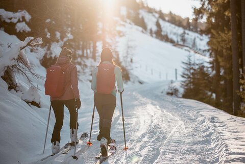 Zwei Schifahrerinnen mit pinken Rucksäcken