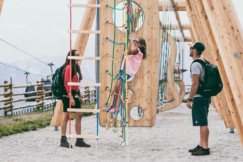 Zwei Kinder klettern auf dem Abenteuerspielplatz