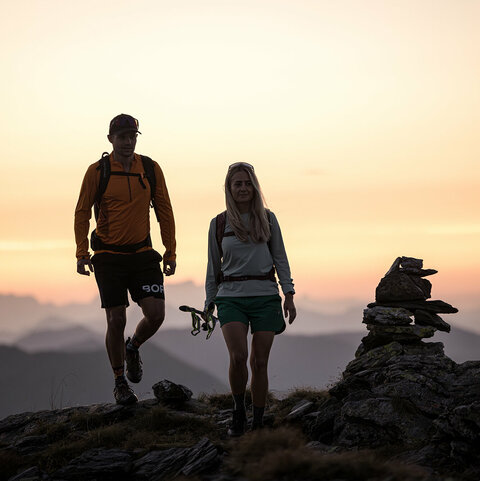 Ein Mann und eine Frau wandern beim Sonnenaufgang