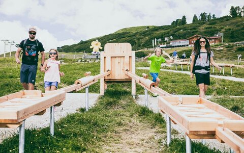 Eine Familie spielt mit einer Holzkugelbahn