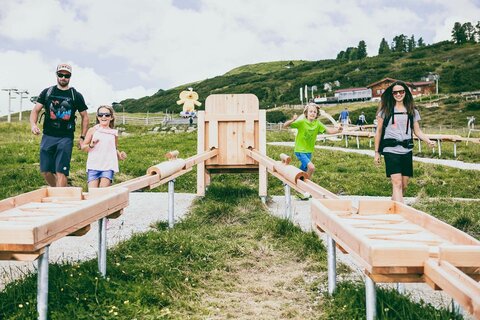 Eine Familie spielt mit einer Holzkugelbahn