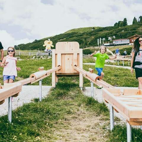 Eine Familie spielt mit einer Holzkugelbahn