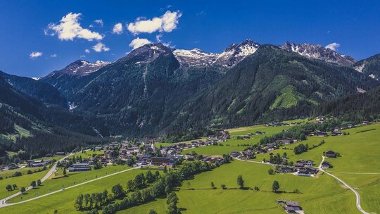 Blick auf ein Dorf vor einer traumhaften Bergkulisse