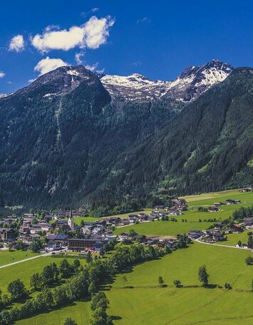 Blick auf ein Dorf vor einer traumhaften Bergkulisse