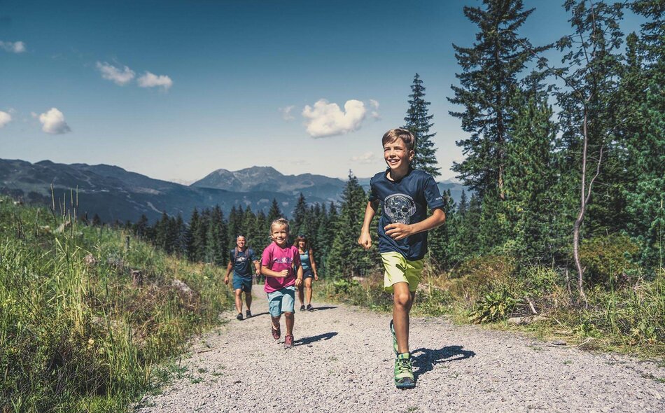 Zwei Kinder laufen einen Gehweg entlang
