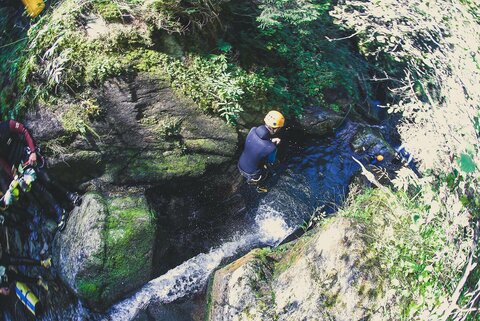 Ein Person springt ins Wasser beim Canyoning.