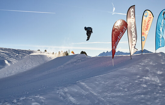 Ein Snowboardfahrer fährt über einen Hügel.