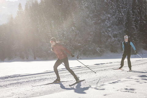 Zwei Langläufer auf einer verschneiten Strecke