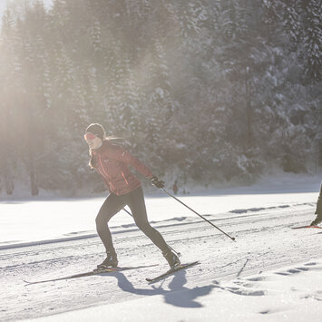Zwei Langläufer auf einer verschneiten Strecke