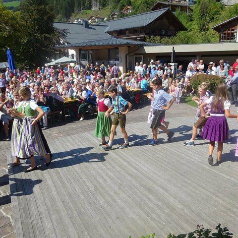 Kinder tanzen zusammen beim Bauernherbstfest