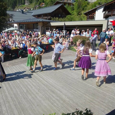 Kinder tanzen zusammen beim Bauernherbstfest