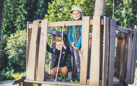 Zwei Jungs sitzen auf einem Baumhaus