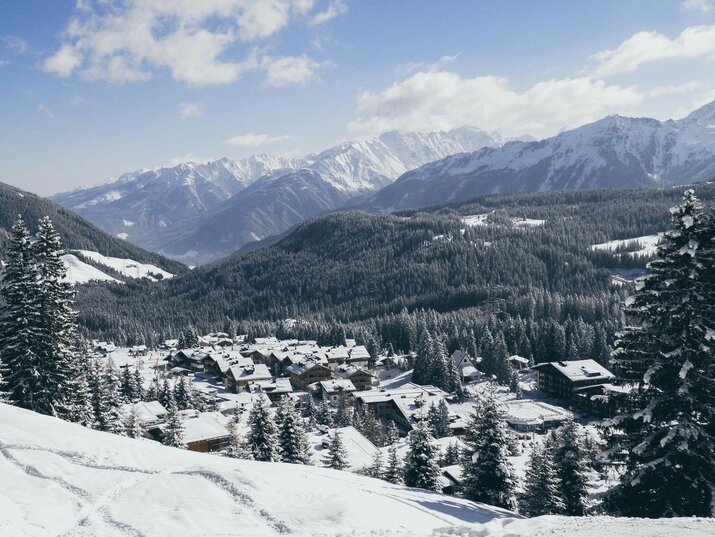 Blick auf ein schneebedecktes Dorf mit verschneiten Häusern und winterlichen Landschaften