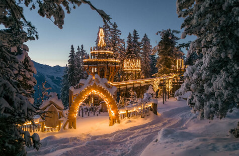 beleuchteter Eingang Fichtenschloss bei Dämmerung
