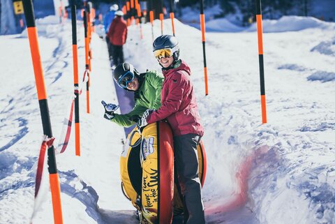 Zwei Personen stellen sich fürs Snowtubing an