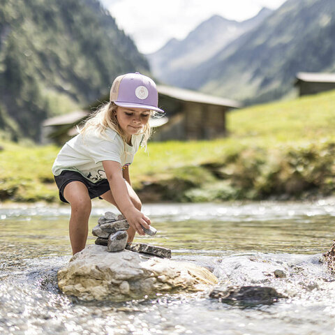 Ein kleines Mädchen spielt im Wasser