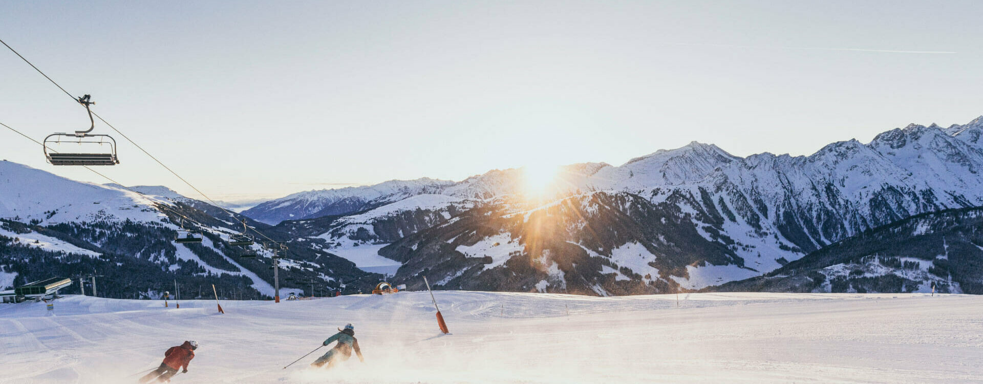 Zwei Skifahrer fahren eine Piste hinunter