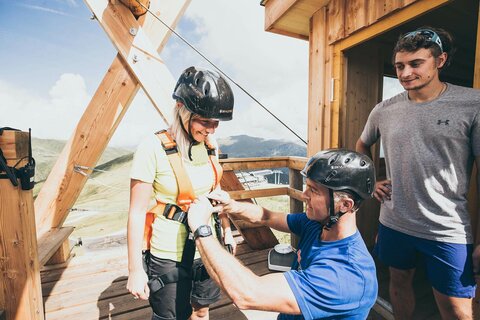 Eine Frau wird mit der Sicherheitsausrüstung für die Zipline ausgestattet