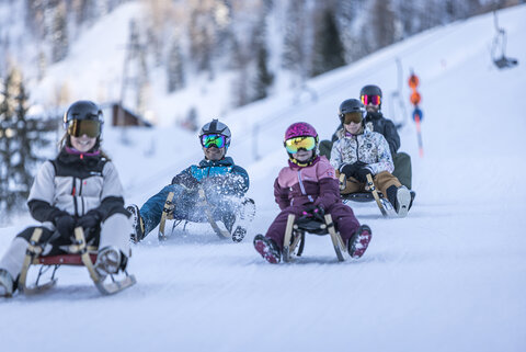 Rodler fahren die Strecke hinunter