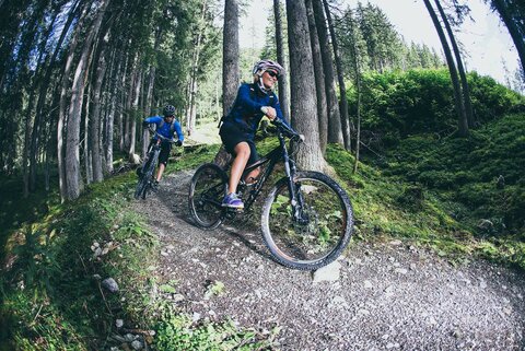 Ein Mann und eine Frau fahren mit Mountainbikes durch den Wald 