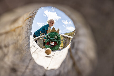 Ein Mädchen spielt mit einer Holzkugelbahn