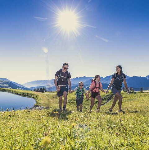 Eine Familie spaziert entlang an einem See