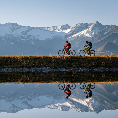 Zwei Radfahrer fahren am Latschensee entlang.