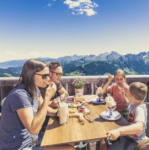 Eine Familie genießt eine Nachspeise auf der Latschenalm.