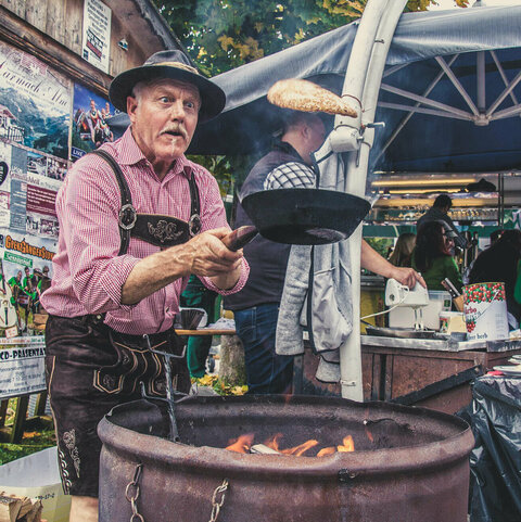 Ein Mann wirft einen Palatschinken in der Pfanne in die Höhe