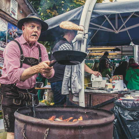 Ein Mann wirft einen Palatschinken in der Pfanne in die Höhe