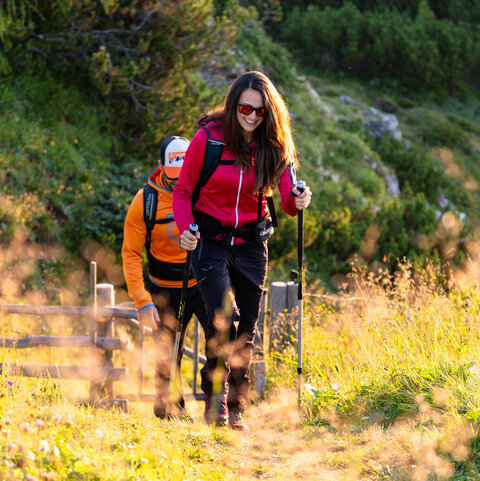 2 Wanderer entlang eines Wanderweges im Herbstlicht