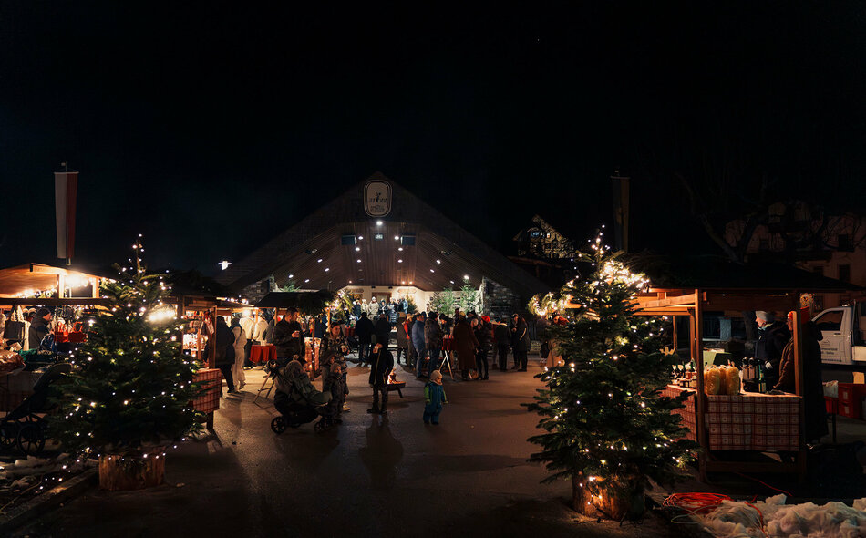 Weihnachtsmarkt mit beleuchteten Christbäumen und Verkaufsständen